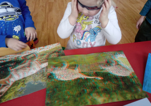 Dziecko ogląda ilustrację dinozaura w okularach 3 D